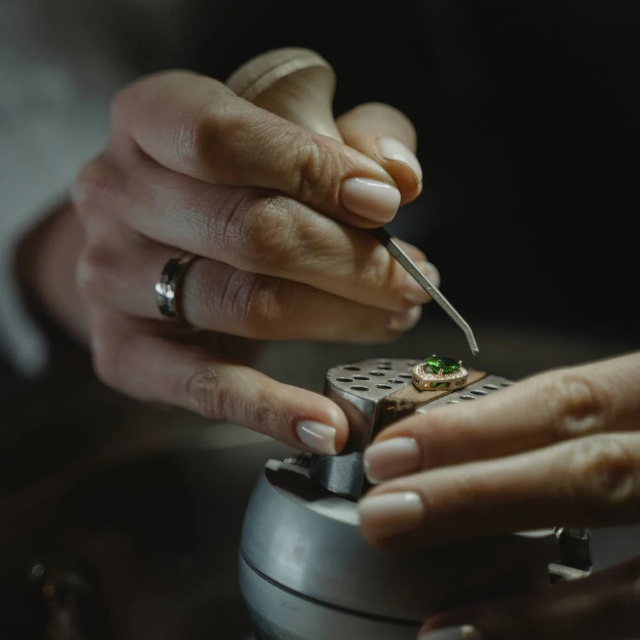 bijoutier en train de sertir méticuleusement une bague. Cette scène met en avant le savoir-faire et la précision nécessaires dans l'art de la joaillerie